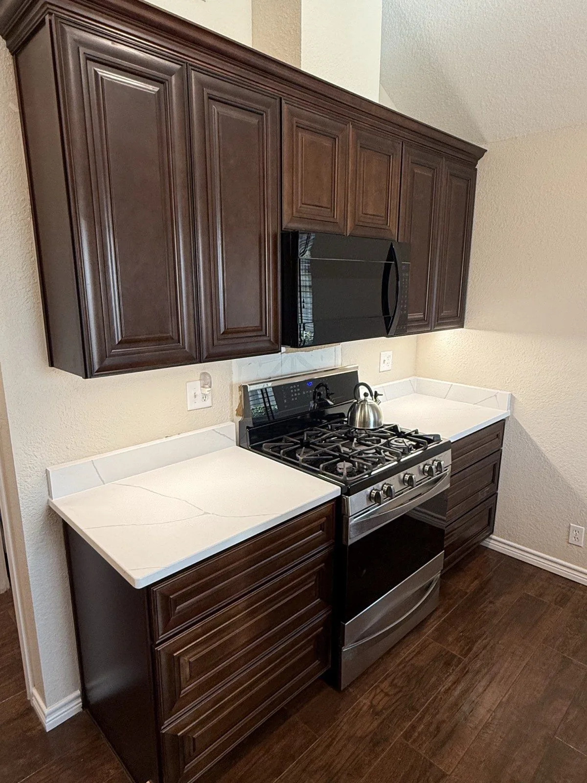 Espresso raised panel kitchen cabinets with white quartz countertops