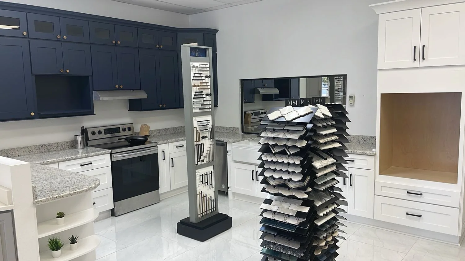 Inside the Cabinet Bazaar showroom in San Antonio with navy and white display kitchens and stone samples