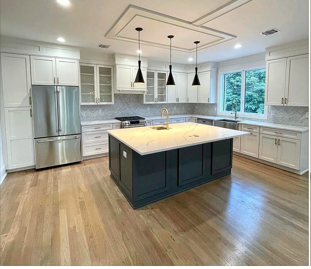 White kitchen with a navy blue island and quartz waterfall countertop