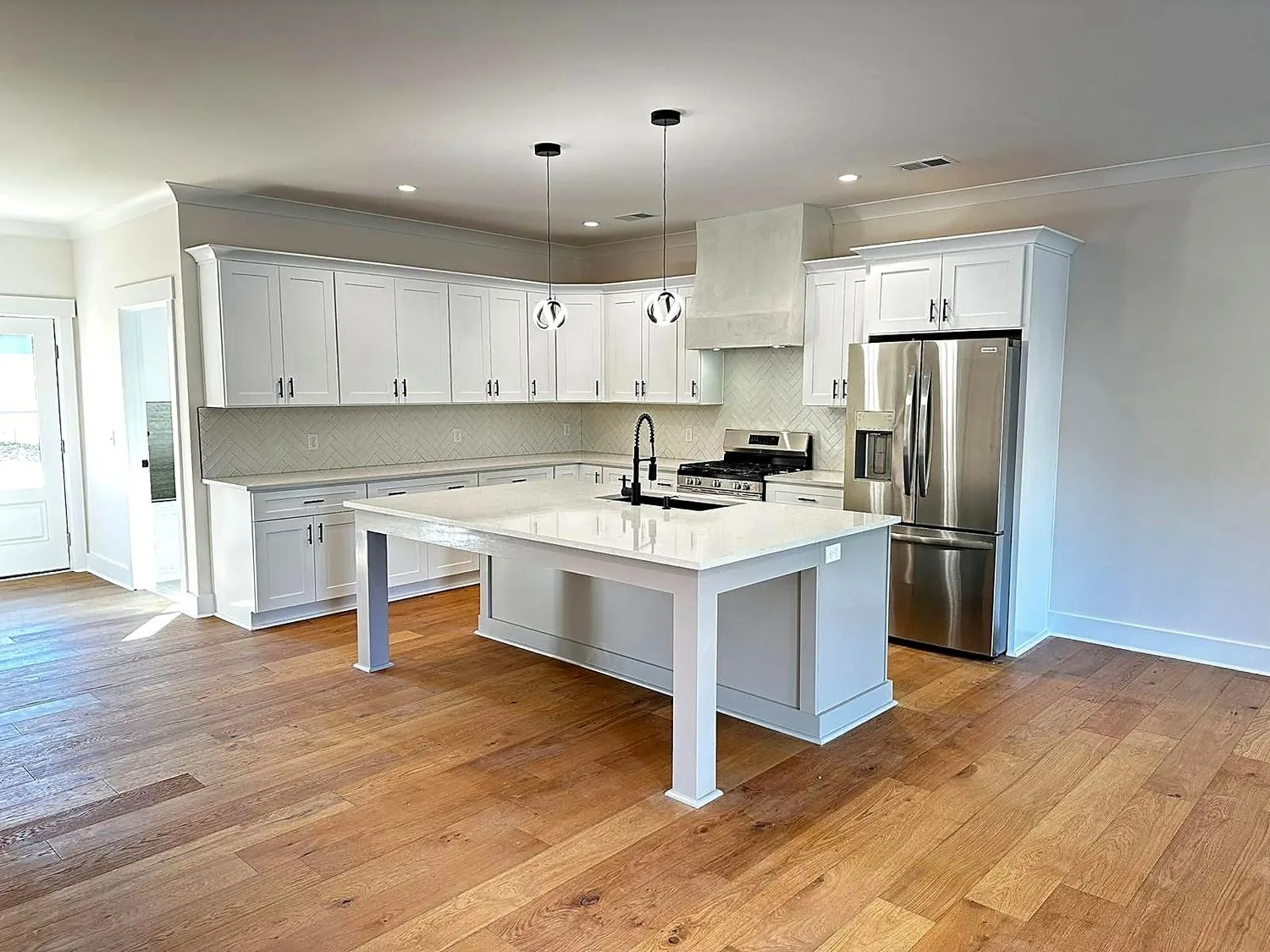 White shaker kitchen with a center island and stainless steel appliances